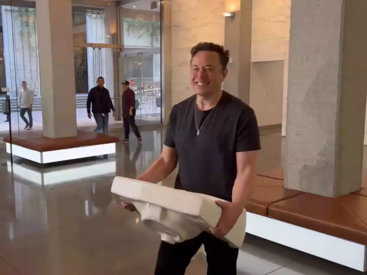 Elon Musk smiling and holding a sink at Twitter HQ